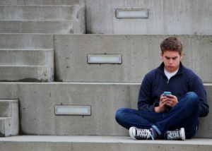 Teenager sitting looking at phone