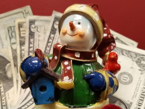 holiday snowman in front of money