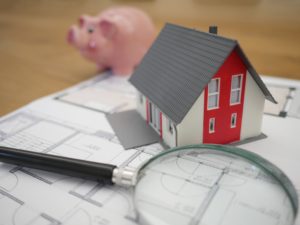 Piggy bank, toy house, magnifying glass