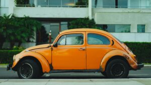 Old orange car parked along the street