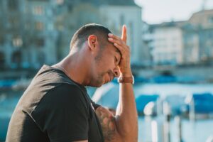 Man holding forehead. 